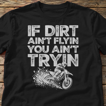 If Dirt Ain't Flyin You Ain't Tryin t-shirt in Black, laid flat on weathered wood