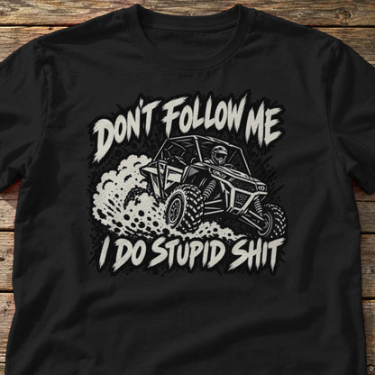 Don't Follow Me I Do Stupid Shit t-shirt in Black, laid flat on weathered wood