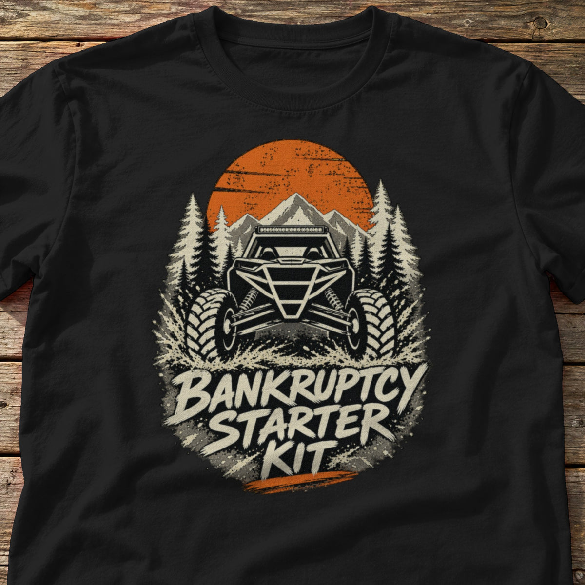 Bankruptcy Starter Kit t-shirt in Black, laid flat on weathered wood