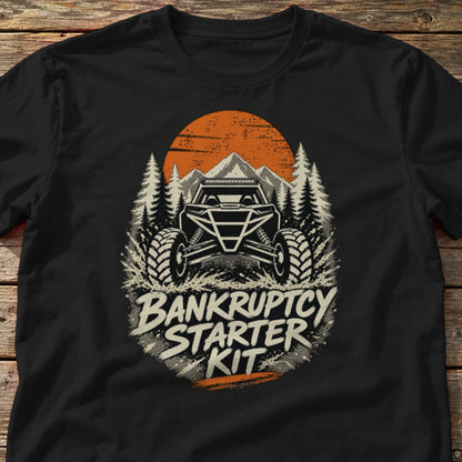 Bankruptcy Starter Kit t-shirt in Black, laid flat on weathered wood