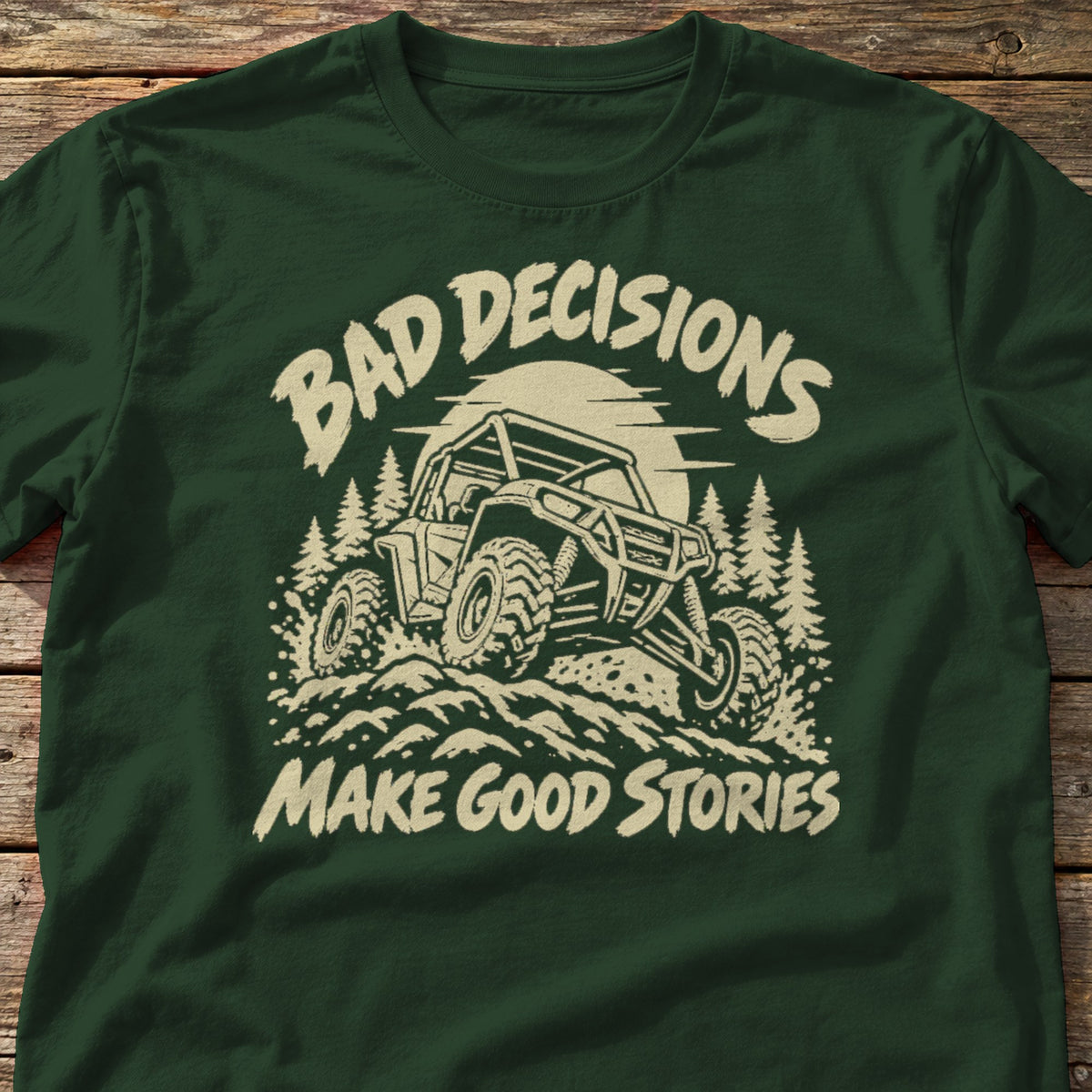 Bad Decisions Make Good Stories t-shirt in Forest Green, laid flat on weathered wood