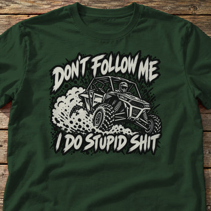 Don't Follow Me I Do Stupid Shit t-shirt in Forest Green, laid flat on weathered wood