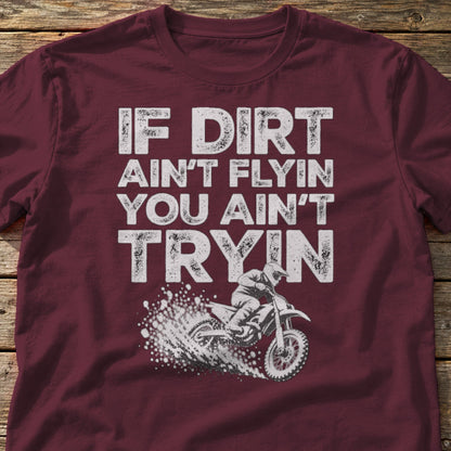 If Dirt Ain't Flyin You Ain't Tryin t-shirt in Maroon, laid flat on weathered wood