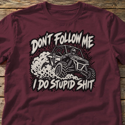 Don't Follow Me I Do Stupid Shit t-shirt in Maroon, laid flat on weathered wood