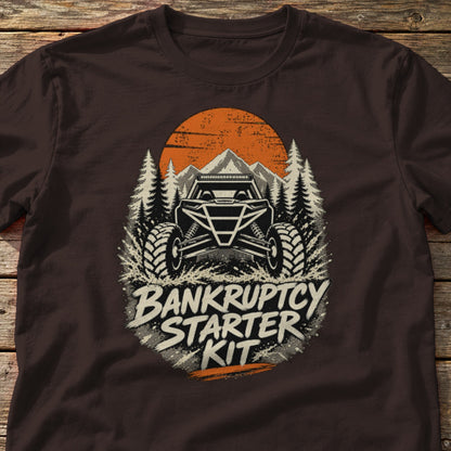 Bankruptcy Starter Kit t-shirt in Dark Chocolate, laid flat on weathered wood