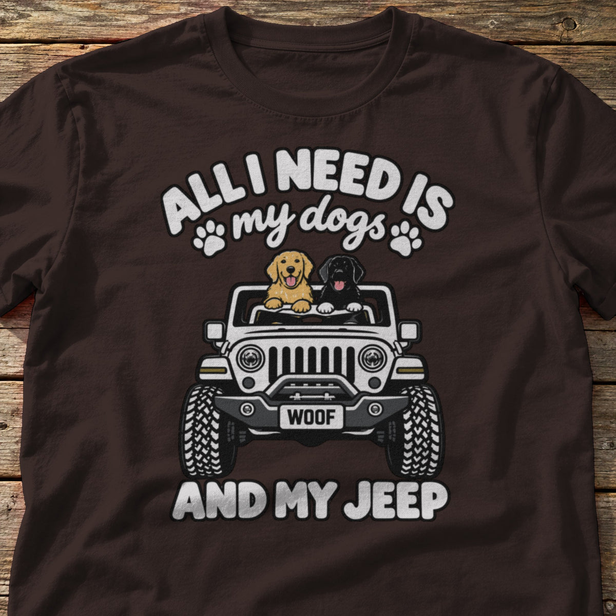 All I Need Is My Dogs and My 4x4 t-shirt in Dark Chocolate, laid flat on weathered wood