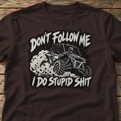 Don't Follow Me I Do Stupid Shit t-shirt in Dark Chocolate, laid flat on weathered wood
