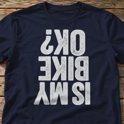 Is My Bike OK? t-shirt in Navy, laid flat on weathered wood